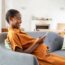 Pregnant african woman using smartphone at home